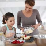 A mother and daughter baking together in a bright kitchen