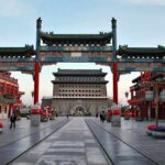 A vibrant traditional Chinese gateway with ornate decorations in an urban setting