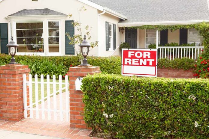 A house with a For Rent sign in the front yard