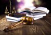A gavel, legal books, and scales of justice on a wooden table