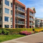 Modern apartment buildings with balconies and landscaped gardens on a sunny day