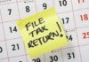 A sticky note on a calendar reminding to file tax return