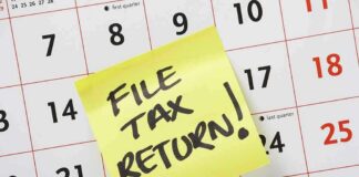 A sticky note on a calendar reminding to file tax return