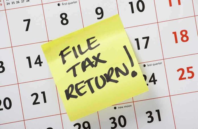 A sticky note on a calendar reminding to file tax return