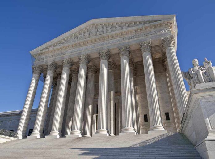 The Supreme Court building featuring grand columns and statues under a clear blue sky