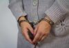 A person wearing handcuffs with their hands clasped together