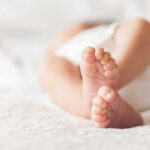 Actress’s Baby Twist: Mother and Grandmother in One! Close-up of baby feet lying on blanket.