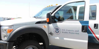 U.S. Customs and Border Protection truck with open door.