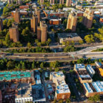 Aerial view of urban area with tall buildings and freeway.