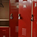 Virginia Schools’ SHOCKING Trans Locker Room Controversy Red lockers with padlocks, one open with hanger.