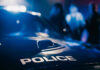 Police car with blurred figures in the background.