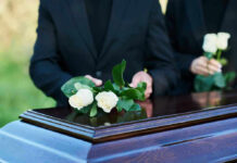 Protest Chaos Erupts—Kash Patel Funeral Interrupted! People placing white roses on a casket.