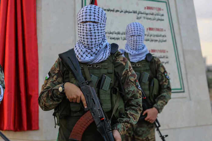 Masked soldiers holding rifles in front of a monument.