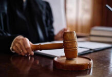 Judge holding gavel in courtroom.