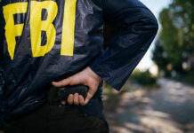 Ex-CIA Official’s $40M Gold Stash Shocks Nation FBI agent holding a gun behind the back.