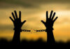 Governor Slashes Sentence—Shocking Election Clerk Release Hands breaking free from chains at sunset.