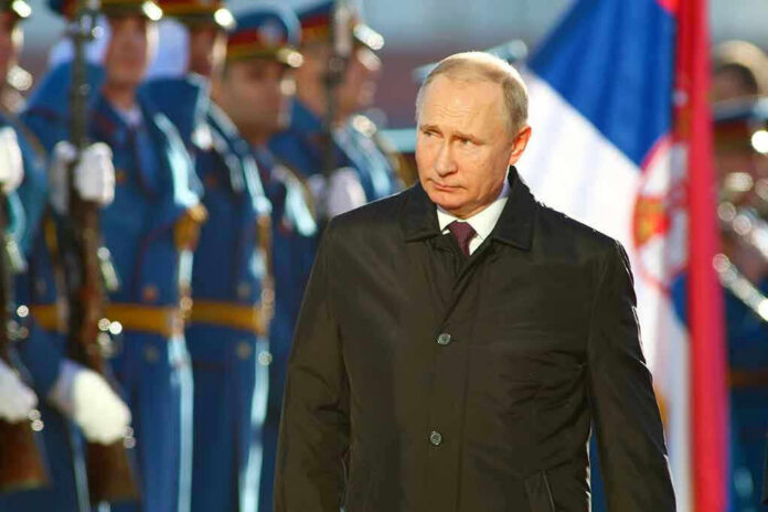 A man in dark coat at a military event.
