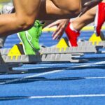 Transgender Athlete Sparks Major Controversy Athletes starting a sprint from starting blocks on a blue track