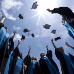 AI Speech BACKFIRES: Former Google CEO Booed Graduating students celebrating by throwing their caps into the air under a bright blue sky