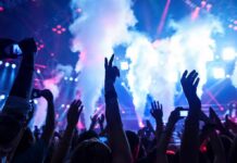 CIA Foils Concert Massacre — Taylor Swift Targeted! Crowd at a concert with hands raised and smoke effects in the background