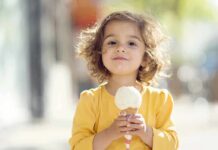 Junk Food Rewires Kids’ Brains—SHOCKING New Findings! A young child with curly hair holding an ice cream cone outdoors
