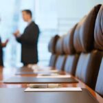 Two business professionals engaged in conversation in a conference room