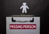 Clipboard with a missing person notice and a paper cutout figure
