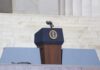 Podium with a microphone and presidential seal in front of steps