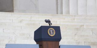 Podium with a microphone and presidential seal in front of steps