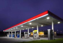 Trump SLASHES Gas Tax Amid $4.52 Gallon Shock A gas station at night with illuminated fuel pumps and a convenience store