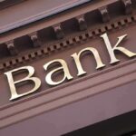 Trump’s Bank Order Sparks Immigration FIRESTORM Close-up of a bank sign with gold lettering