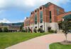 Donor’s Shocking Move: $2 Million Debt Erased Modern educational building on a college campus with landscaped grounds
