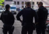 Hostage Drama Ends With FBI Gunfire Three police officers standing on a city street.