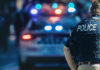 World Cup Terror: Highway Shooter Vanishes Police officer with patrol car and flashing lights.