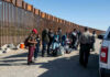 Border patrol agents interact with a group of people.
