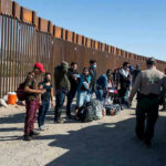 Trump Scores Major Border Win Border patrol agents interact with a group of people.