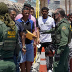Child Star Sparks ICE Uproar Border patrol agents inspecting group of individuals in line.