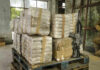 Stacked packages on a pallet with a rifle.