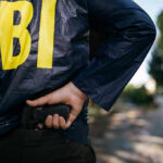 FBI Storms City Hall Inner Circle FBI agent holding a gun behind the back.