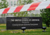Iran Cash Bombshell? JD Vance Fires Back U.S. Embassy sign behind red-and-white caution tape.