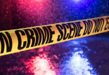 Wrong Car, 80 Rounds, One Shocking Ambush Yellow crime scene tape with police lights in background.