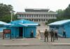 Hezbollah Pause—Who Really Wins? Military personnel standing near blue buildings at a border crossing