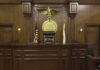 9–0 Shock: Marijuana Users Keep Guns Interior of a courtroom featuring a judges bench and American flag