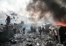 Record Barrage Slams Ukraine A chaotic protest scene with smoke, fire, and people holding flags