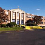 Facebook Threats Jolt Catholic School Exterior view of a brick school building with yellow steps and a cross on top