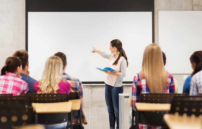 Education,,High,School,,Teamwork,And,People,Concept,-,Smiling,Student A teacher presenting to students in a classroom