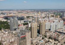 Aerial view of a sprawling urban city with high-rise buildings and green spaces