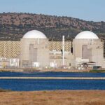 Iran Dismantles Nukes? Not So Fast Nuclear power plant with domed structures beside a water body and mountains in the background