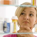 Weight-Loss Shots vs. Cancer A woman thoughtfully looking at a medicine cabinet filled with various medications