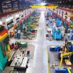Factories Roar Back in US—But Why Now? Aerial view of a large industrial workshop filled with various machinery and equipment